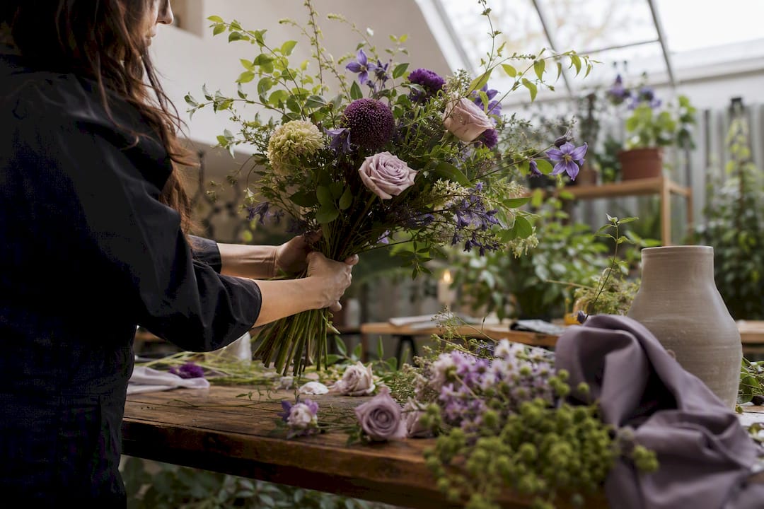 Florist arranging custom bouquet with stems