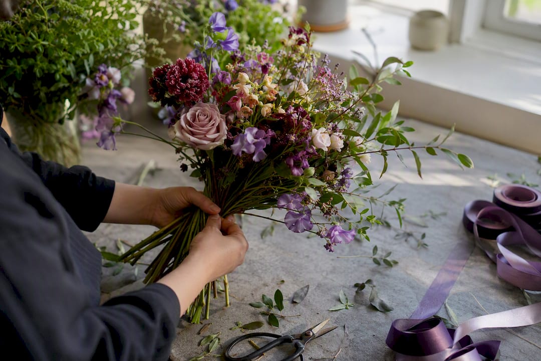Hands tying hand-tied spiral bouquet