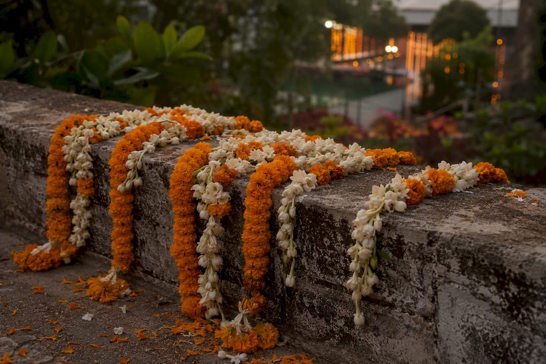 Combined marigold and jasmine garlands on wood railing