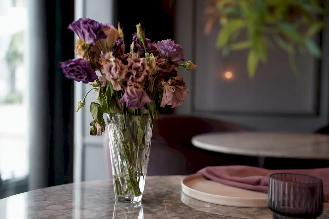 Fading restaurant table flowers illustrating freshness loss