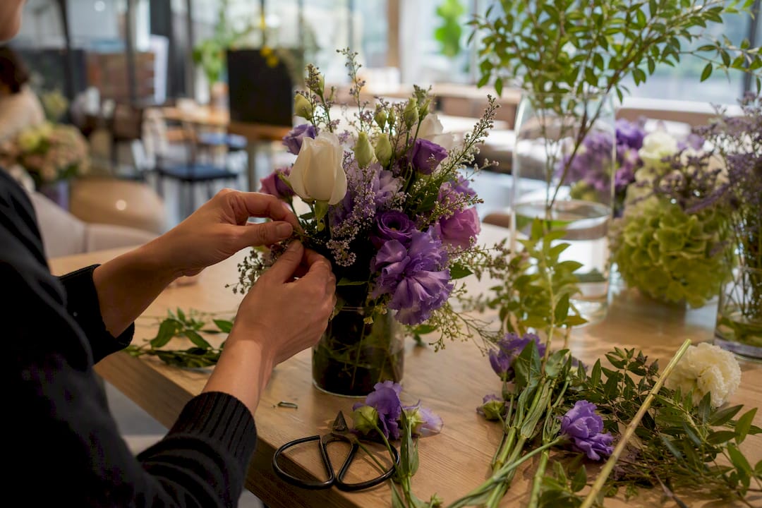 Florist trimming restaurant flowers by hand