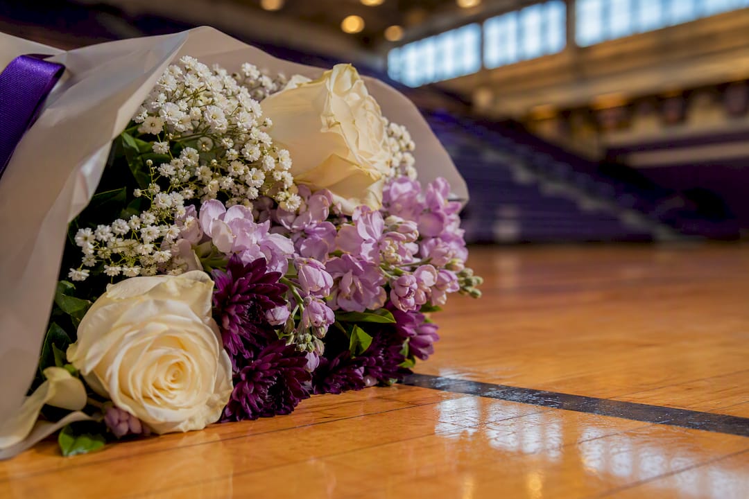 Cropped graduation bouquet in gymnasium