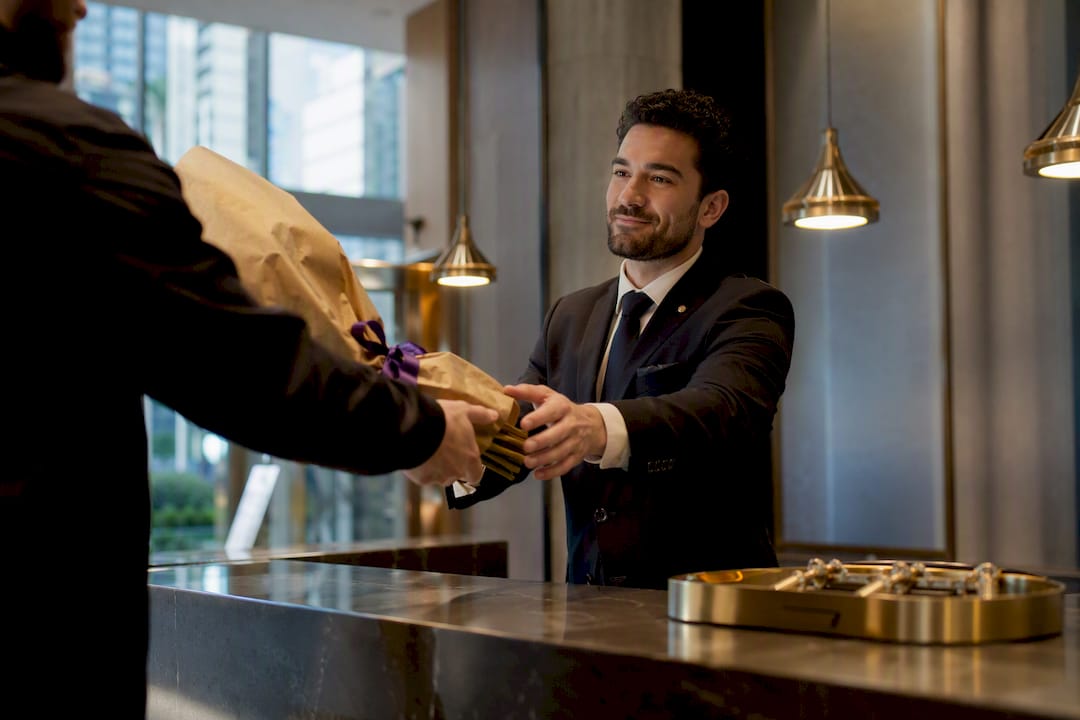 Concierge receiving wrapped hotel flower delivery
