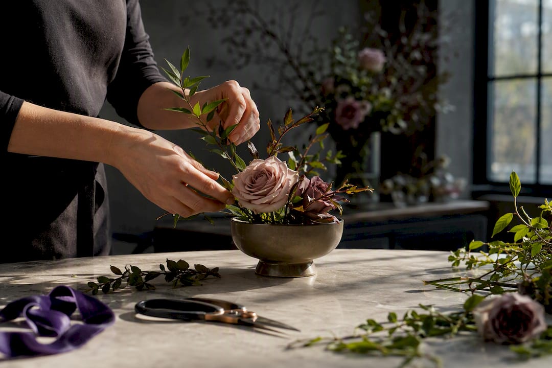 Hands arranging event flowers in workshop