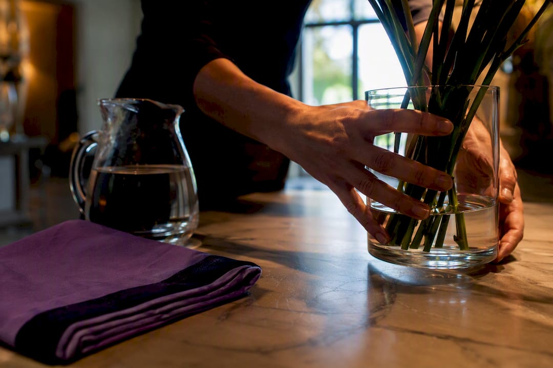 Florist changing water for event flowers