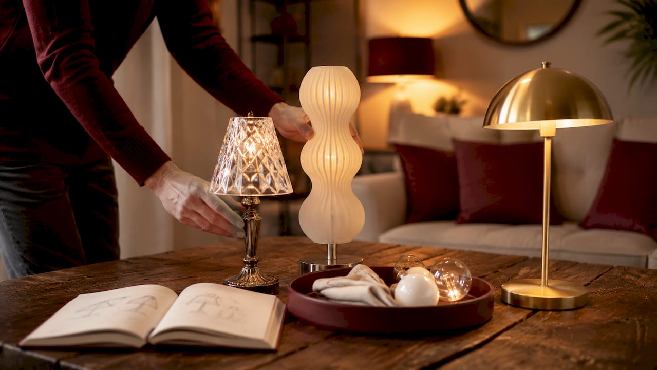 Hands arranging bulbs and fixtures for layered lighting