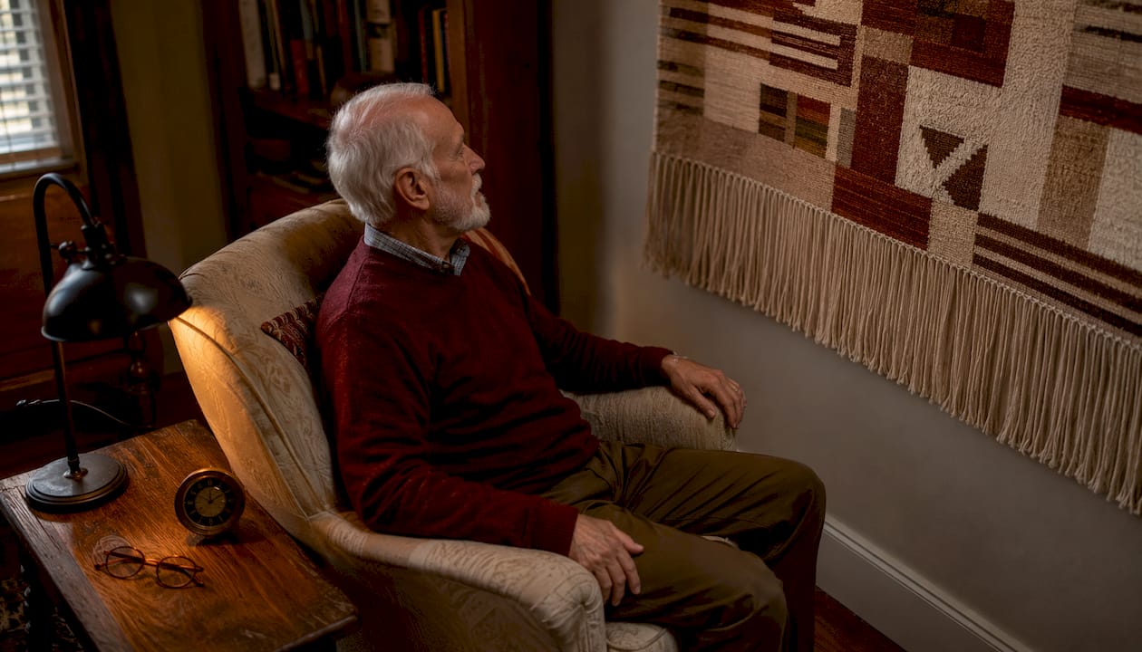 Elderly man appreciating handmade textile