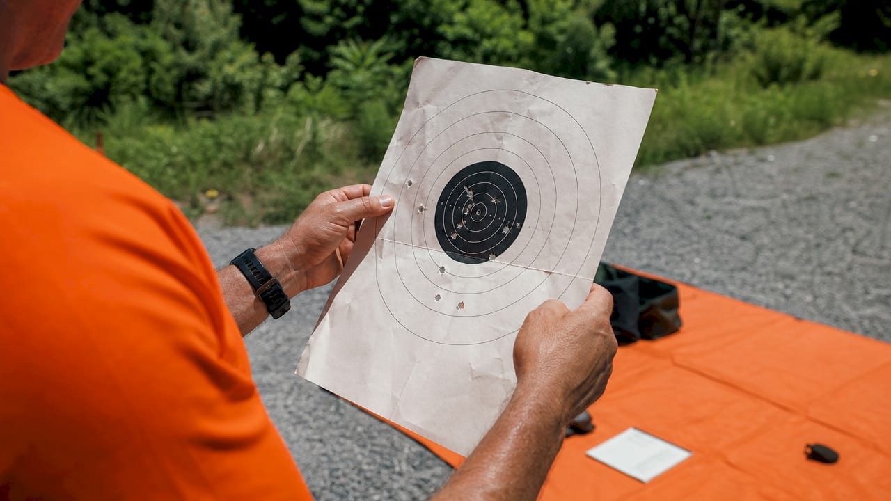 Instructor examining pistol target scoring