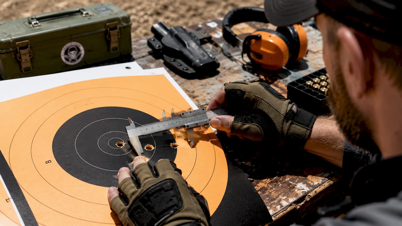 Close-up measuring bullet hole distance on target