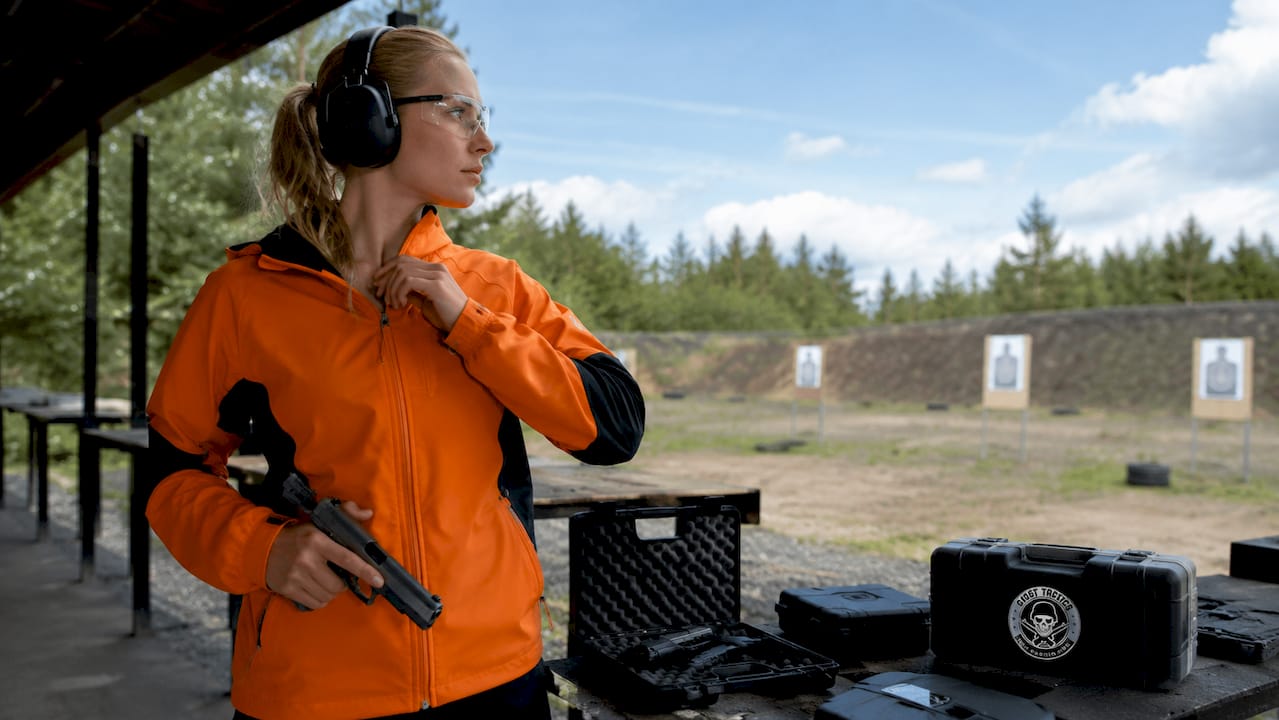 Shooter adjusting safety gear indoors