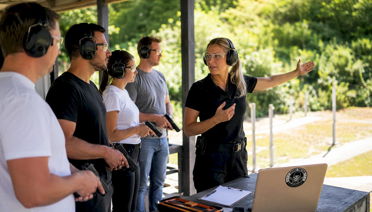 Female instructor briefing visitors at indoor shooting range