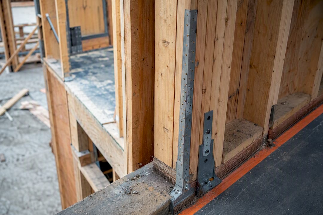 Close-up of wood shear wall segment with hold-downs