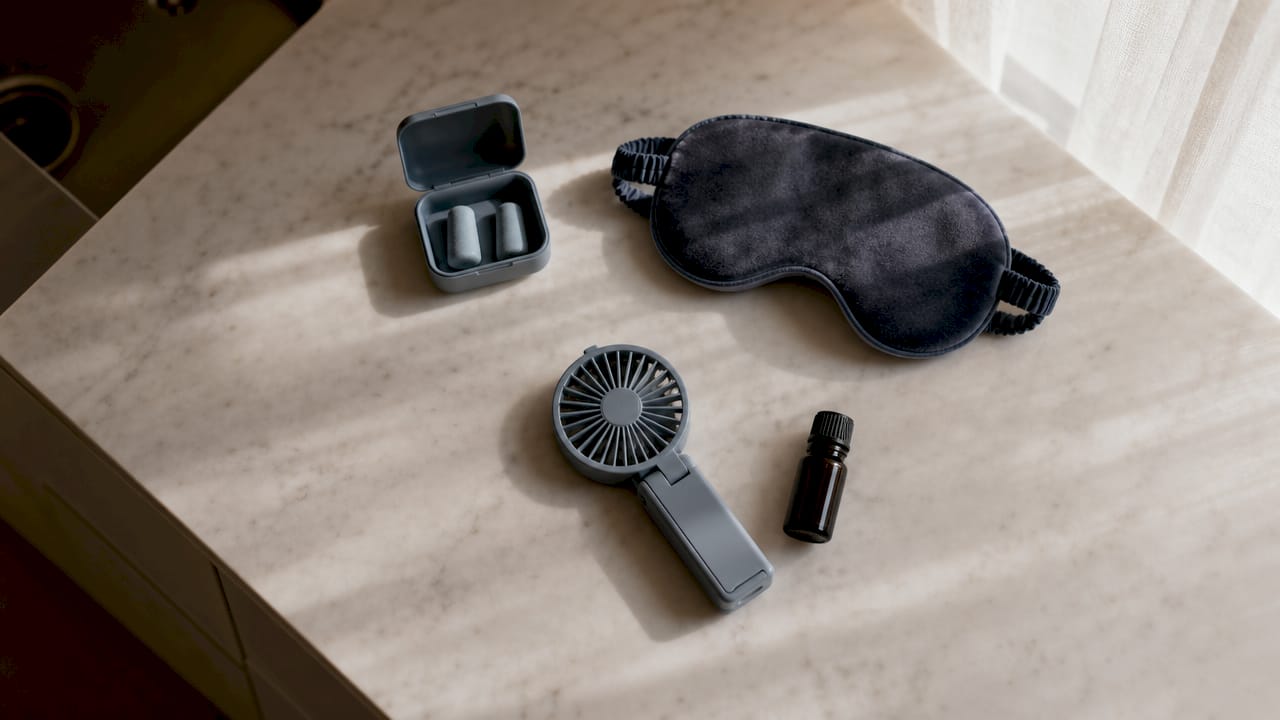 Sleep kit essentials arranged on hotel bedside table