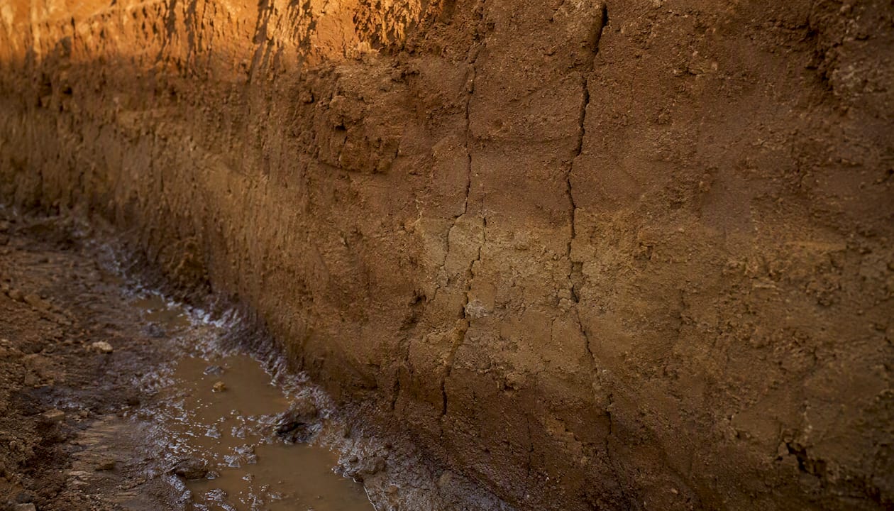 Trench wall showing tension cracks and water seepage