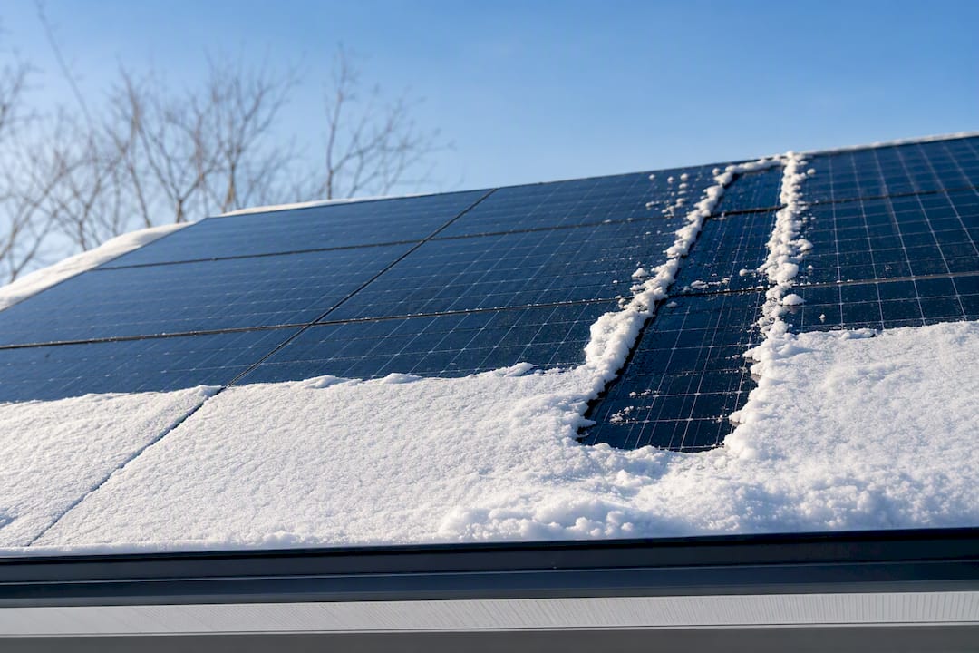 Snow shedding from sloped rooftop solar panels