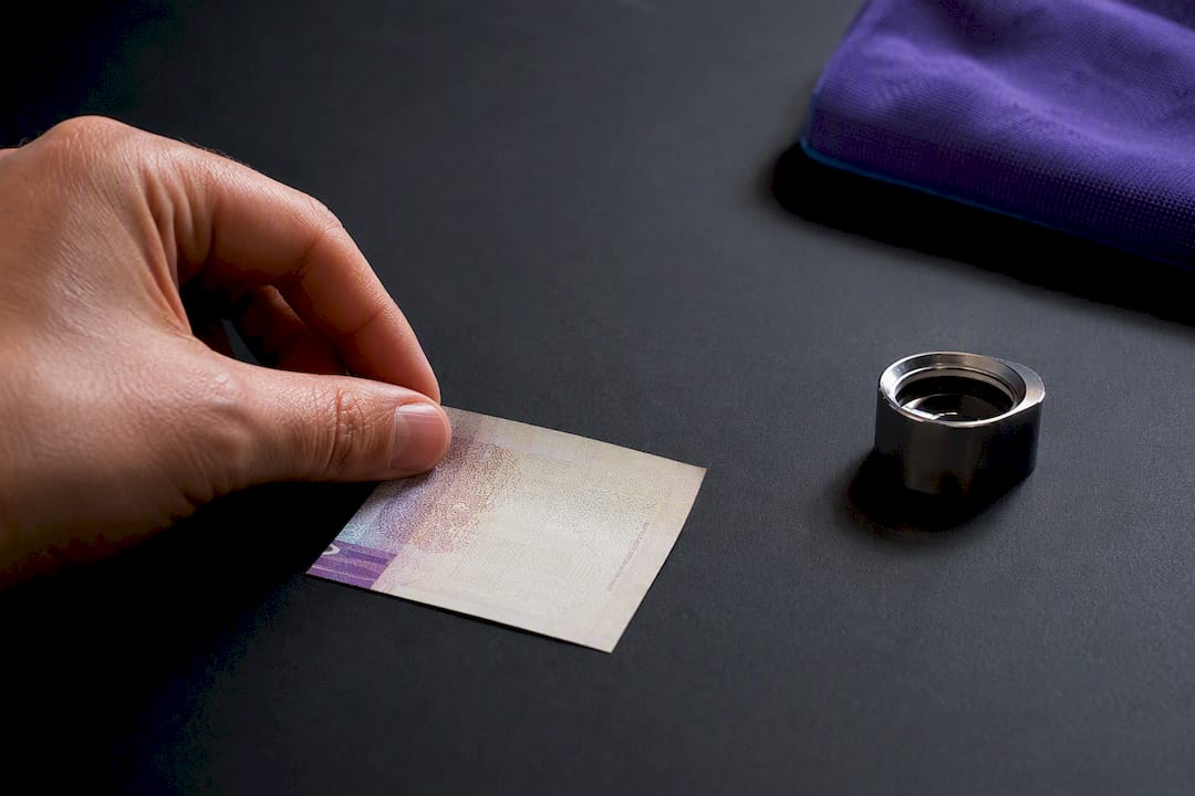Billete parcialmente fotografiado sobre una superficie oscura