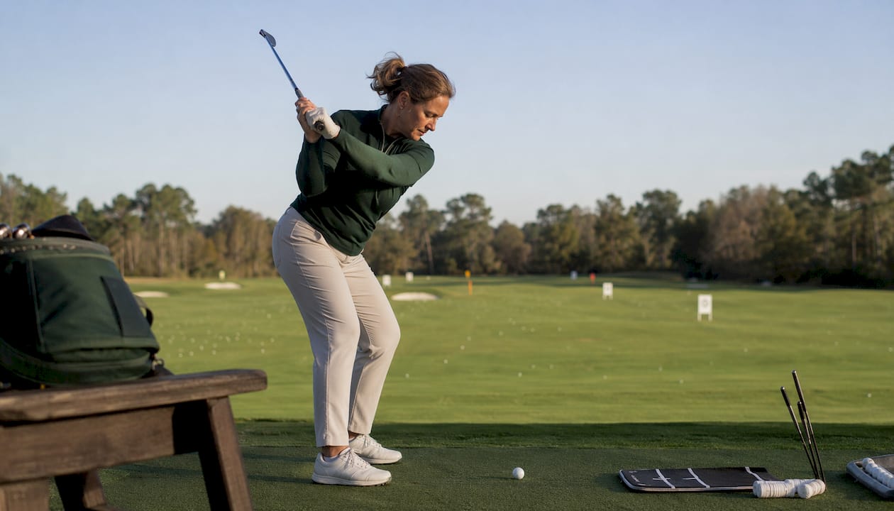 Woman practicing focused iron shots indoors