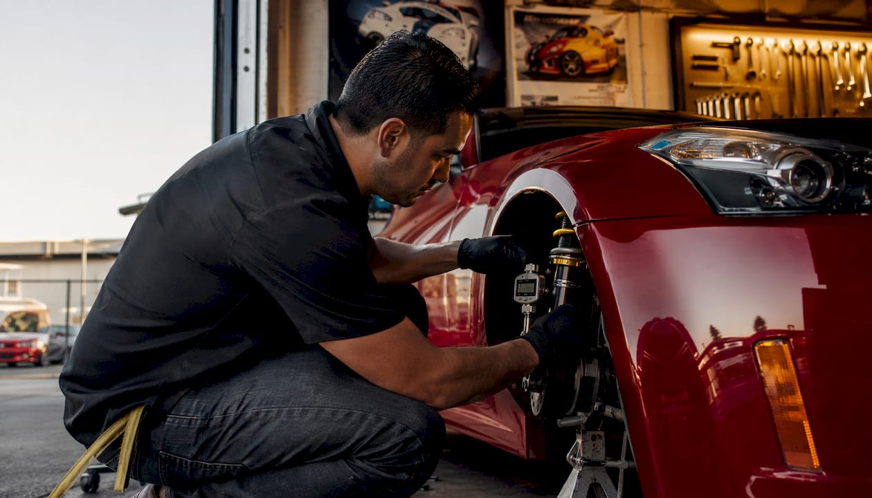 Technician tuning 350Z coilovers for track alignment