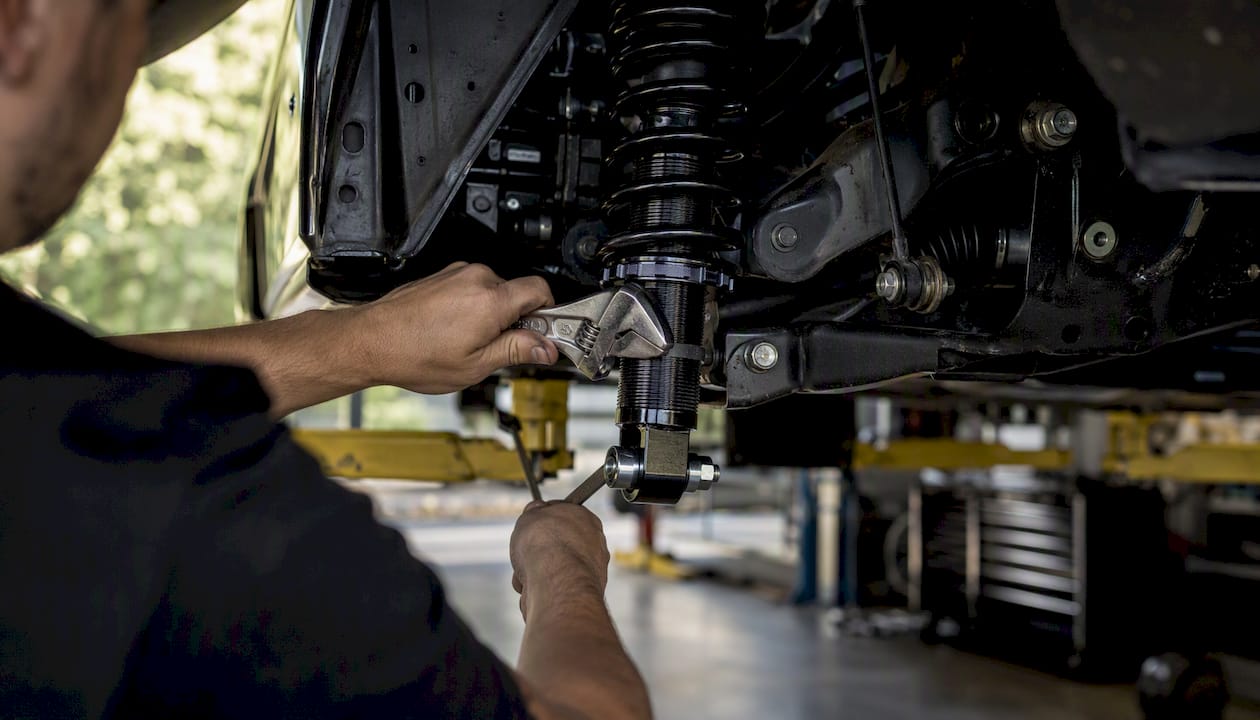 Adjusting coilover body length at suspension compression