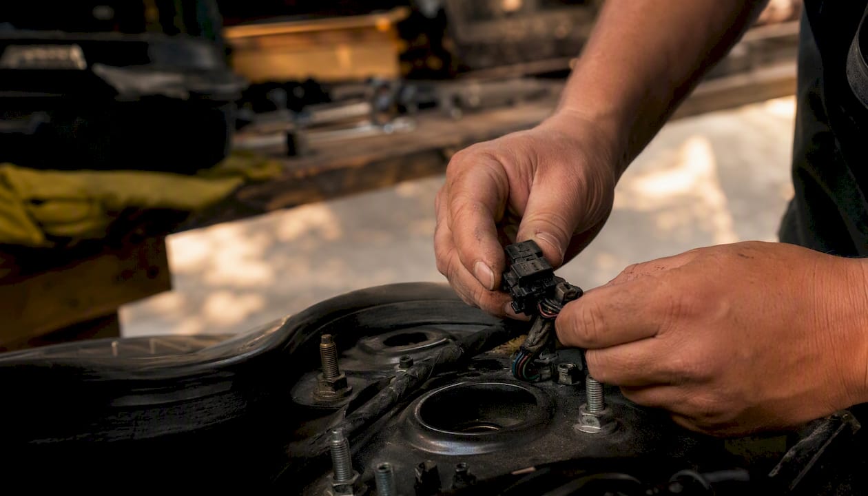Hands disconnecting EDC connector on Supra strut