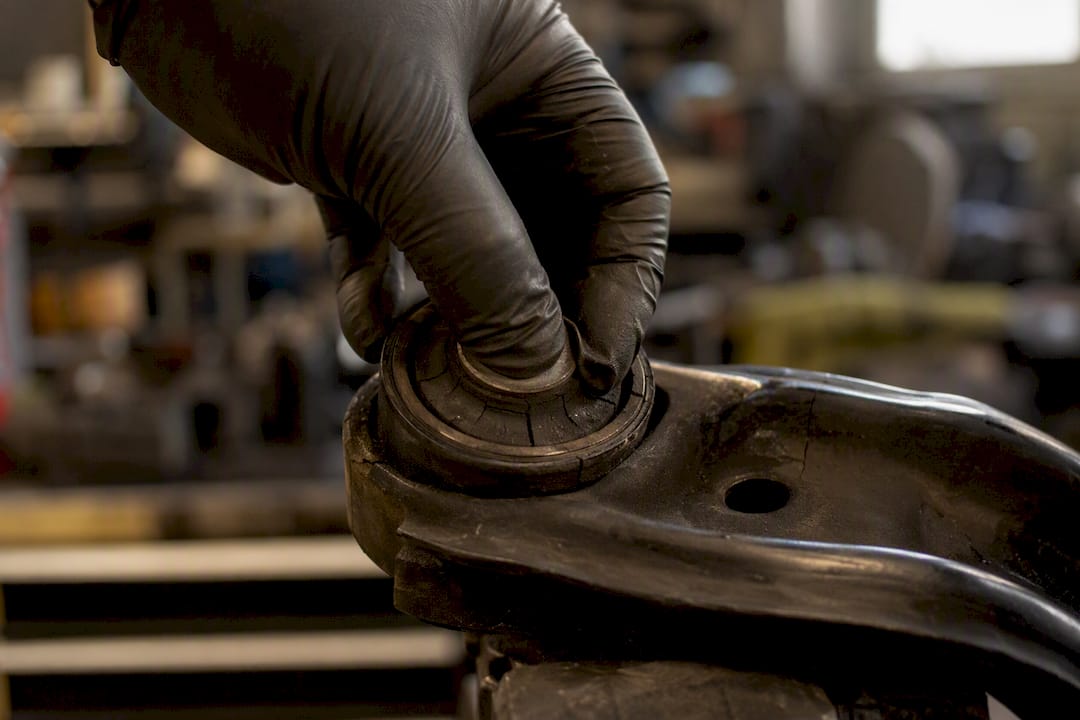 Mechanic inspecting worn suspension bushing
