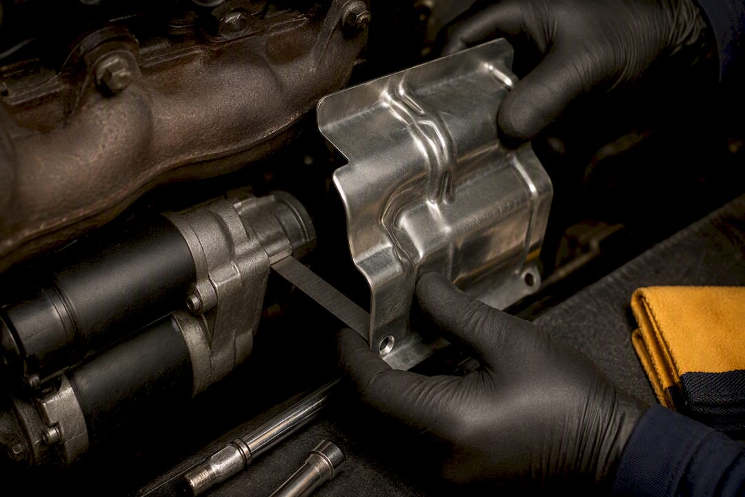Heat shield positioned beside starter housing