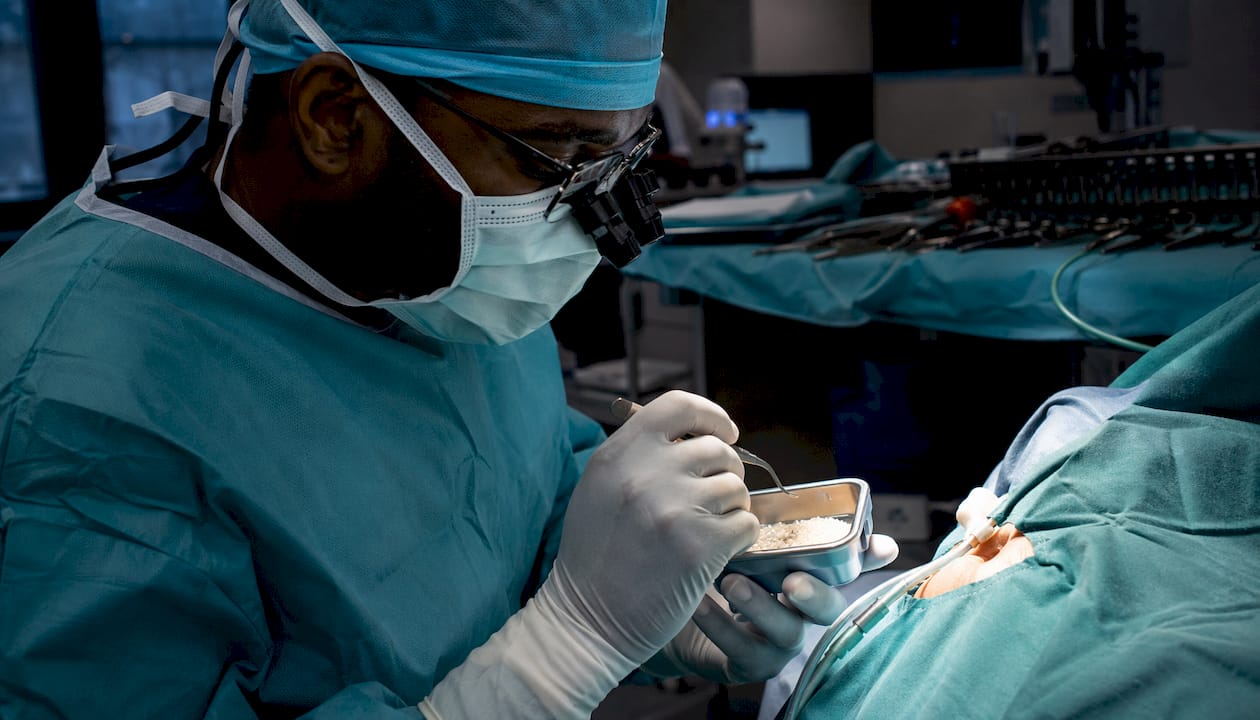Surgeon placing graft in sinus lift lateral window