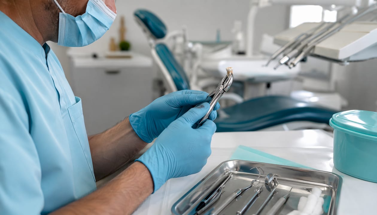 Dentist hands using forceps for tooth extraction