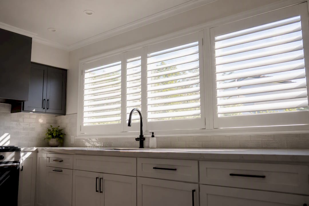 Bay window plantation shutters with tilted louvers