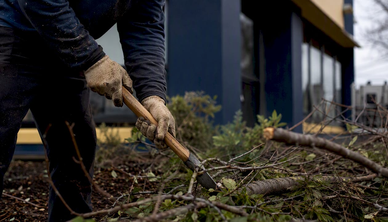 Worker clearing storm debris near commercial building