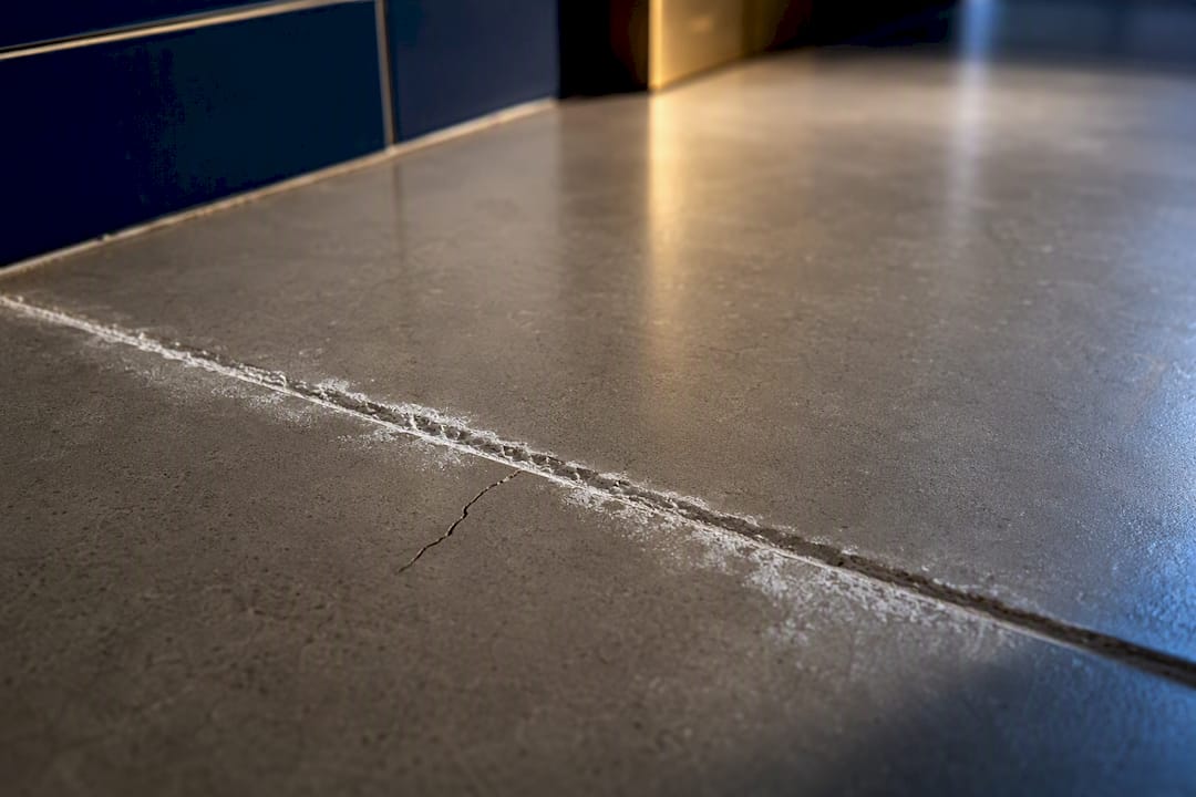 Chalky efflorescence on cracked tile grout