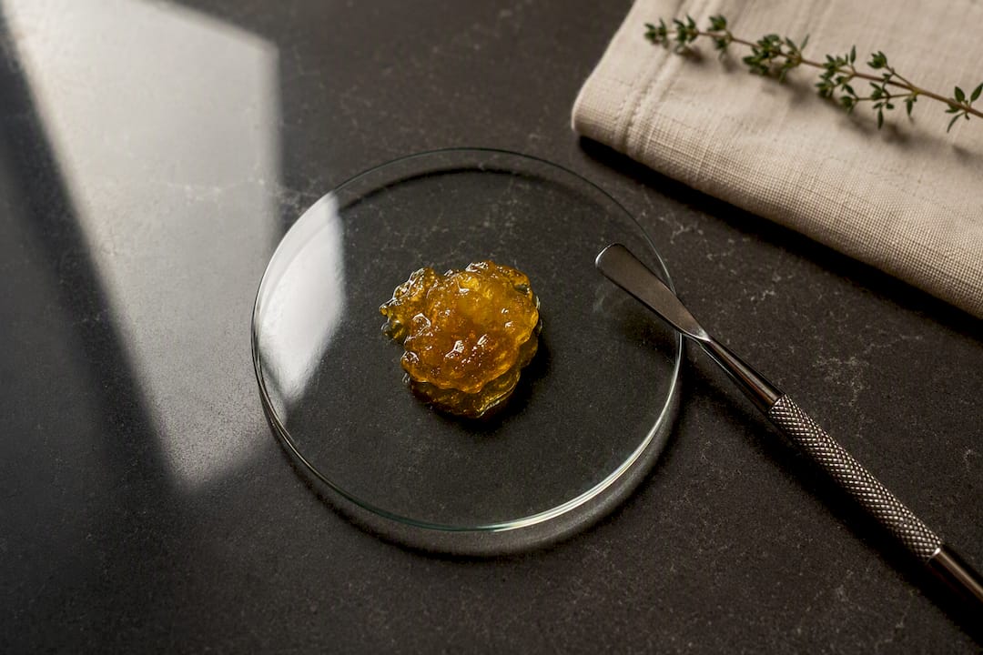 Amber live resin beside extraction tool