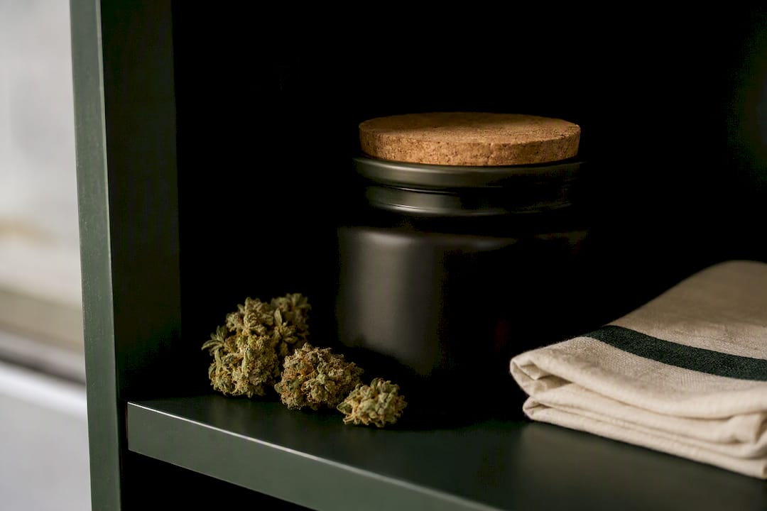 Anonymous flower fragments beside storage jar