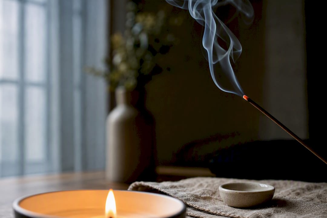 Candlelight and incense smoke in quiet ritual