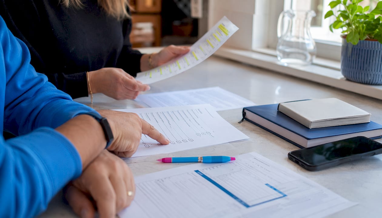 Hands reviewing car sale checklist overhead