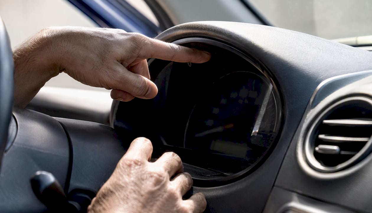 Hands inspecting car odometer