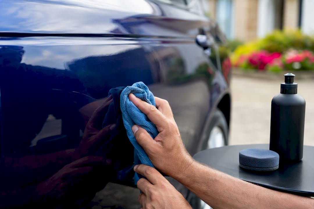 Hands polishing car scratch outdoors