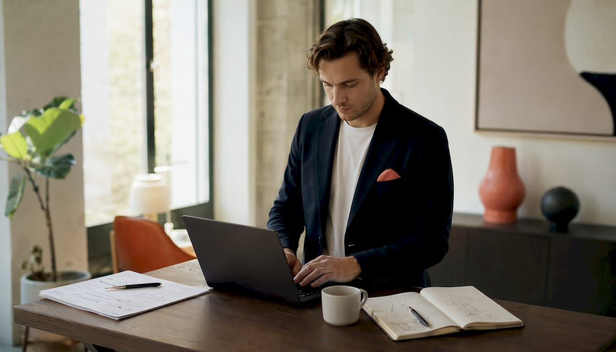Ein Projektmanager arbeitet konzentriert an seinem Laptop im modernen Co-Working-Space.