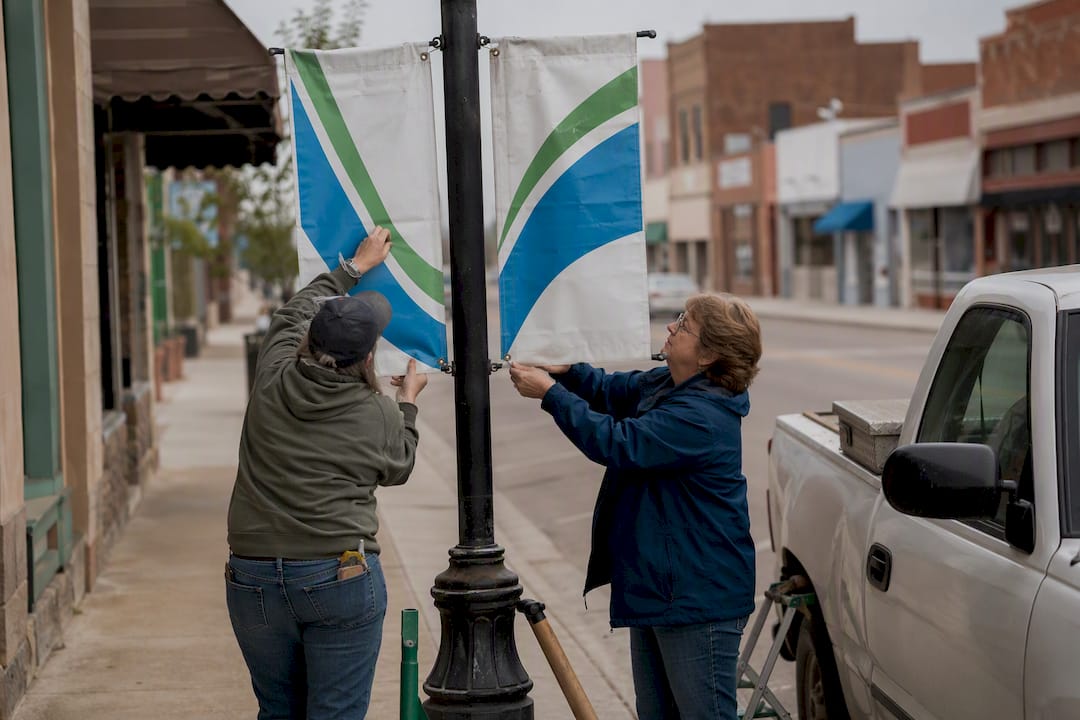 Hands installing banners on downtown street light