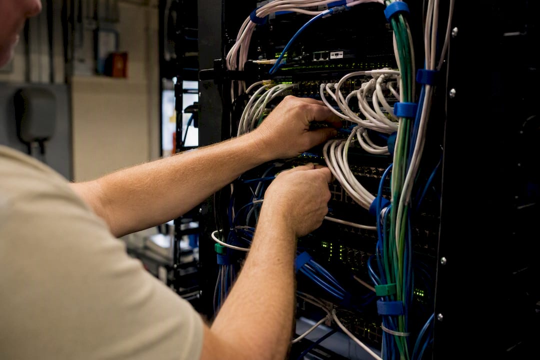 Hands managing city server cables in rural office