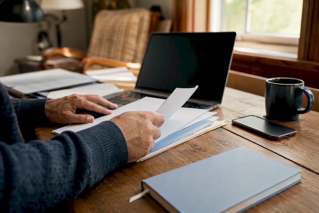 Hands arranging marketing materials in rural office