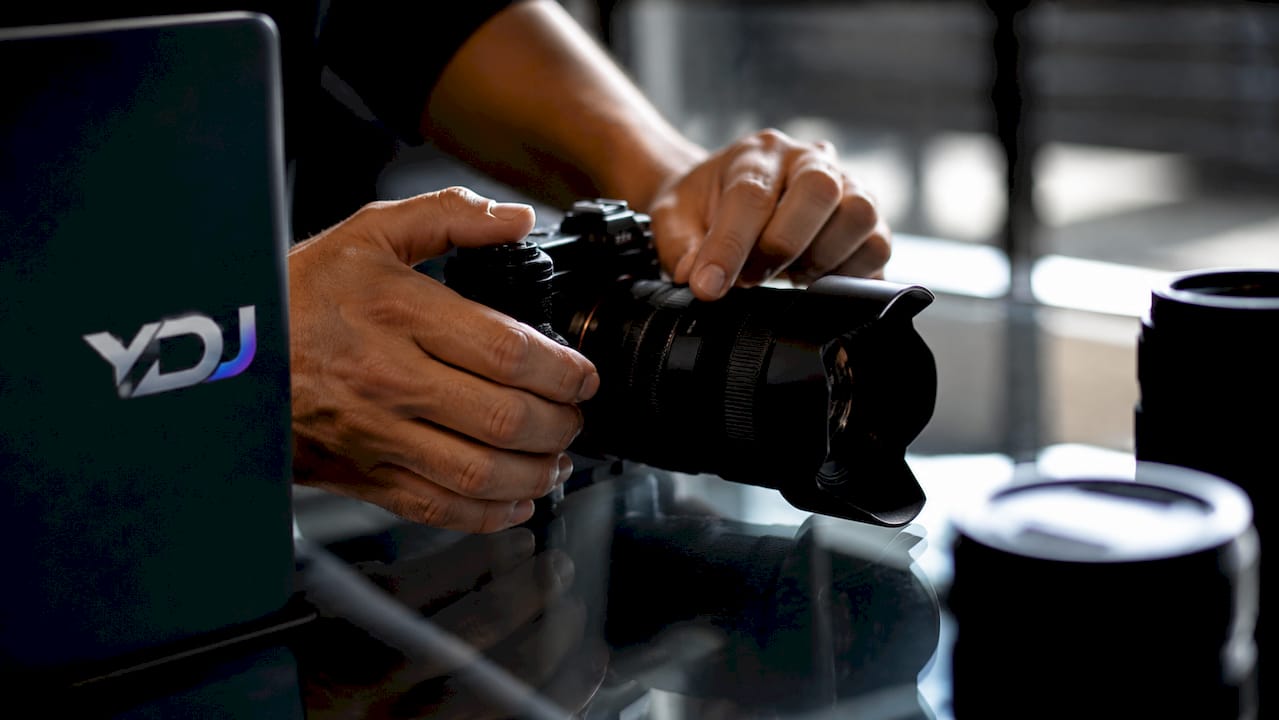 Hands adjusting camera focus over printed photos