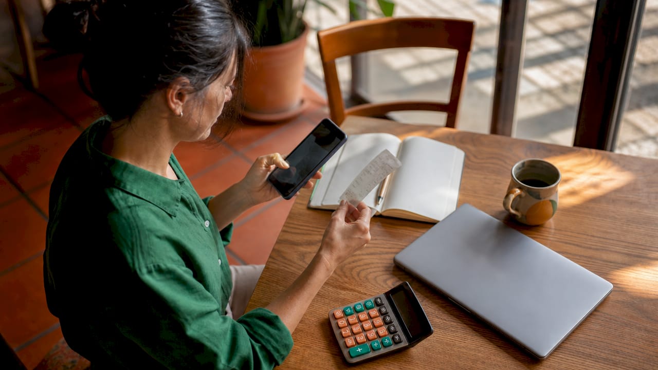 Small business owner tracking expenses at home office