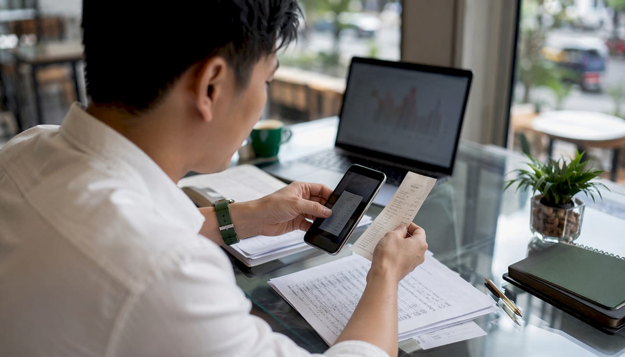 Hands scanning receipts for automated financial data
