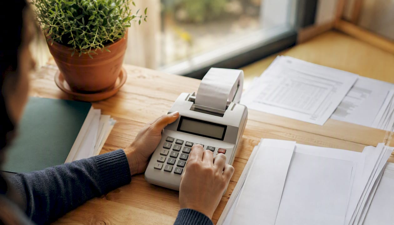 Hands using calculator for business expenses