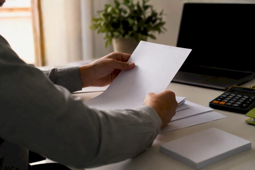Hands entering expense data on desk