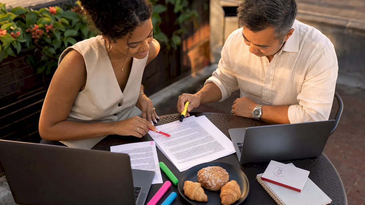 Two borrowers researching mortgage terms at library