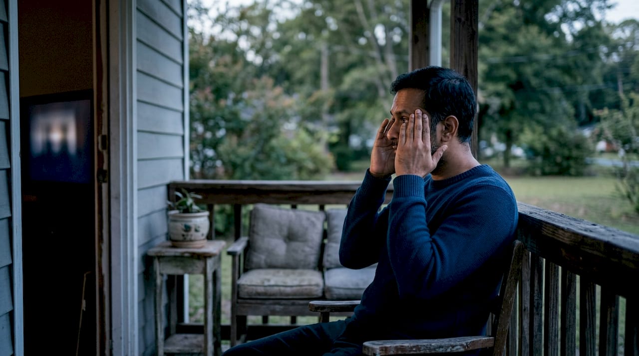 Man stressed watching news TV at home