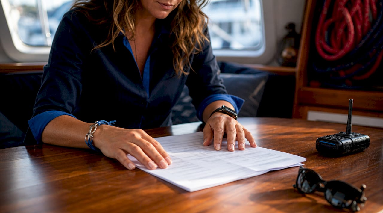 Skipper explaining charter options with documents and radio