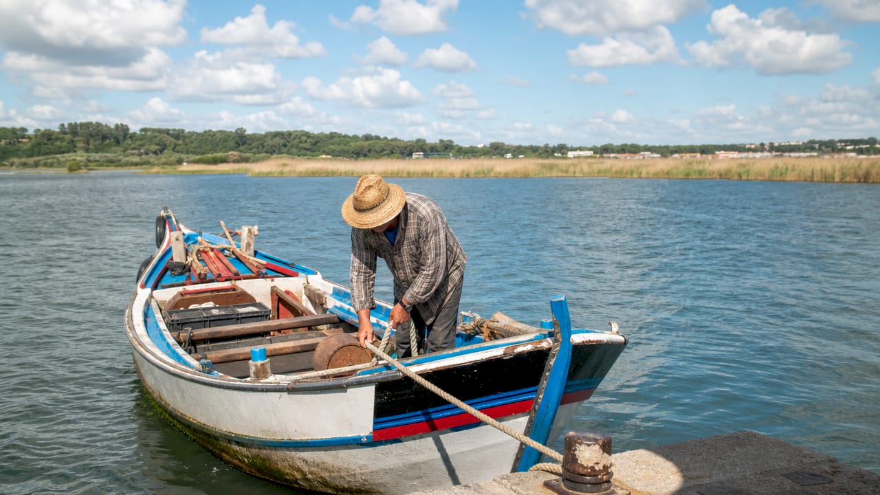 Traditional varino boat with fisherman on Tagus River